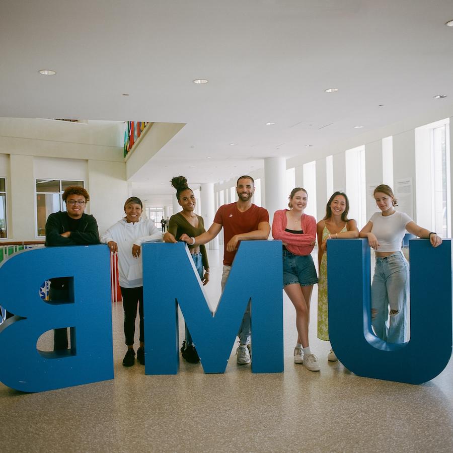 Students behind UMB sign