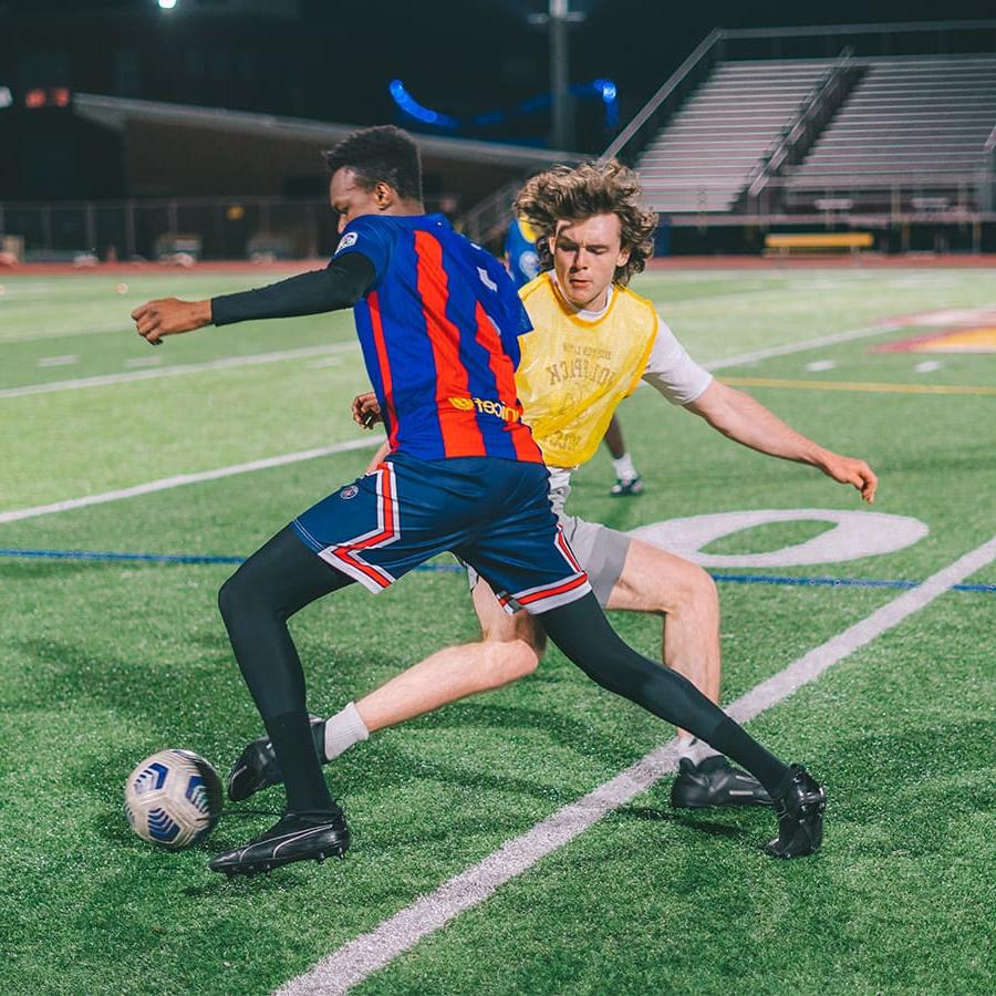 Two students play soccer.